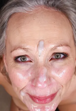 Lots of boring cum on the eyes and face of a sexy old woman, close-up view from above