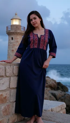 A stunning Palestinian woman standing proudly on a windswept coastal cliff at dusk, her silhouette framed against a weathered stone lighthouse. She wears traditional embroidered *thobe* dress in deep indigo with intricate crimson tatreez patterns along the sleeves and collar, the fabric clinging to her full, curved figure as sea gusts billow the skirt. Her olive-toned skin glows warmly against the twilight, dark curls escaping her *shattaweh* headdress to dance across high cheekbones. One hand rests gently on the lighthouse's sun-bleached base while the other gathers her garment against the breeze, gaze fixed on distant storm clouds gathering over the Mediterranean horizon where waves crash violently against jagged rocks below. The composition balances her powerful presence with the stoic lighthouse, both enduring symbols against the vast, turbulent seascape., ((LIGHTHOUSE VISIBLE IN BACKGROUND))