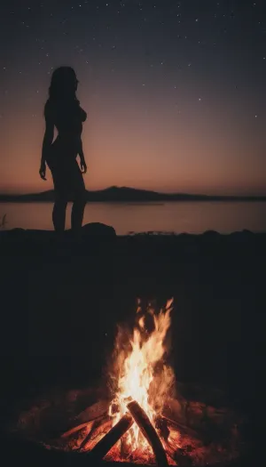 一个女人坐在营火旁,看着火焰。 她忍不住在她面前看着闪闪发光的火焰舞,感到渴望的感觉. 打电话要拍照时 她注意到一些事情