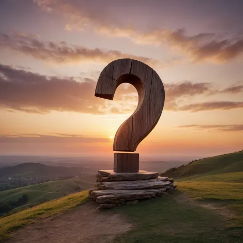 A big wooden question mark 10 meters high on a hill in front of a sunset
